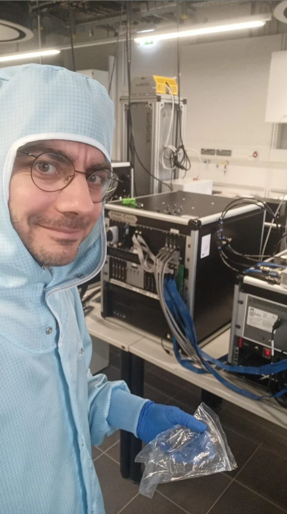 Engineer in cleanroom clothing beside an ARKEO system during installation