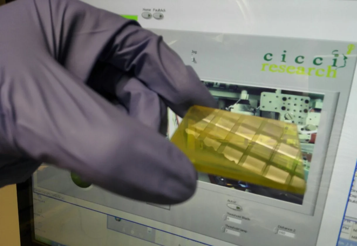 Gloved operator handling a device in front of the ARKEO software interface