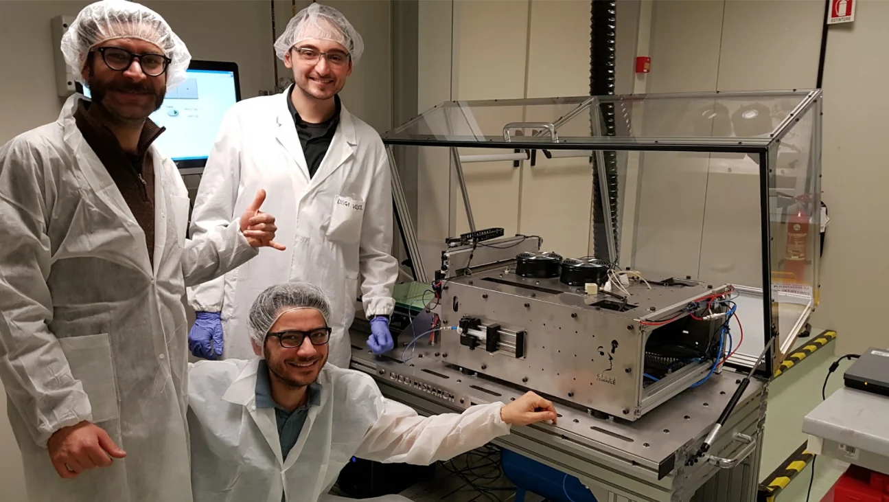 Installation team beside a custom ARKEO system in the laboratory